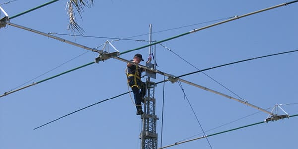 Image of a service operator atop an antenna making adjustments